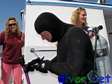 Mark Perlstein cleans his mask, Carol Beck and Kristen in the background